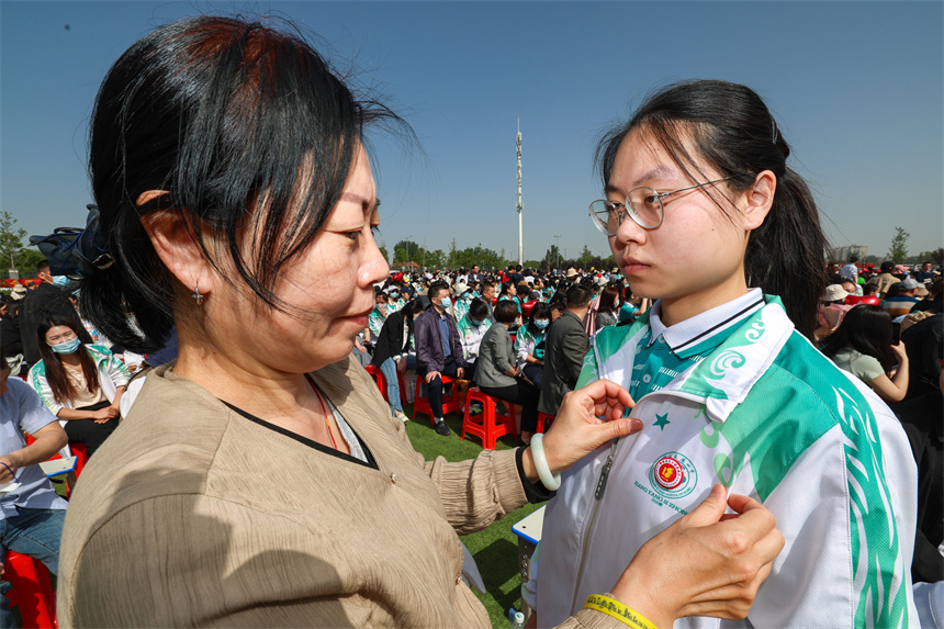 家長給孩子佩戴成人徽章。 