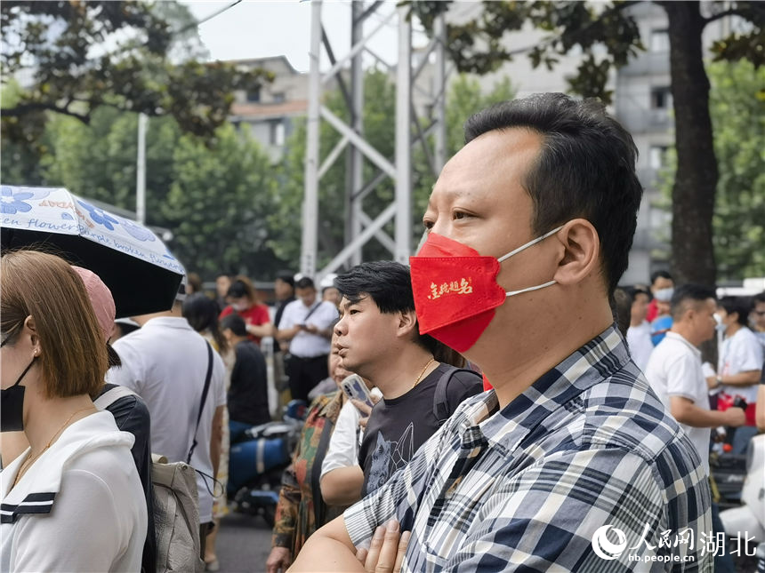 在武漢市第二十六中學考點外，送考家長戴著印有“金榜題名”的口罩。人民網(wǎng)記者 周雯攝