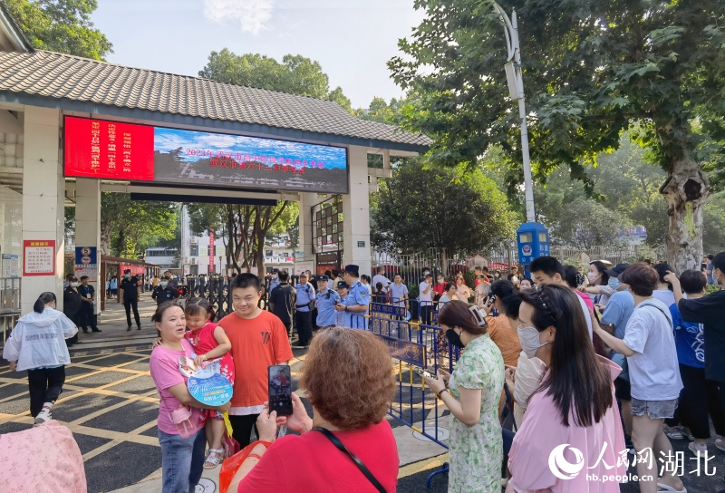 武漢市第六十三中學(xué)考點外，送考家長和學(xué)子一起合影留念。人民網(wǎng)記者 周雯攝