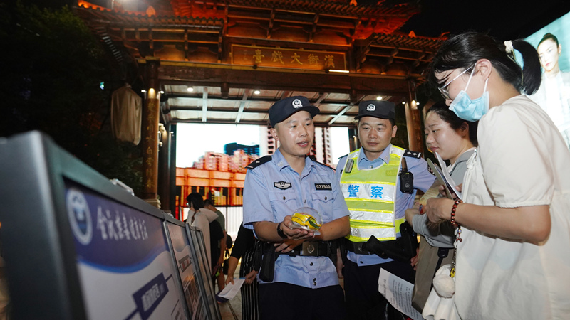 7月7日小暑時節(jié)，武昌區(qū)公安分局漢街派出所民警冒著夏日的炎炎高溫在漢街大戲臺向來往游客宣傳防騙禁毒知識。孫遜攝