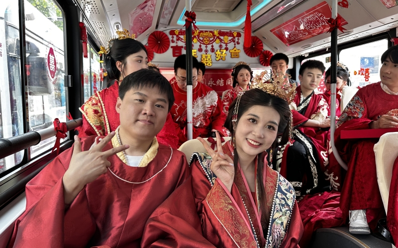 新人集體乘坐公交婚車，踐行低碳環(huán)保新風(fēng)尚。