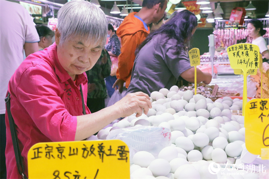 5月30日上午，一位老人在洪山廣場地鐵站菜市場挑選雞蛋。人民網(wǎng)記者 周恬攝