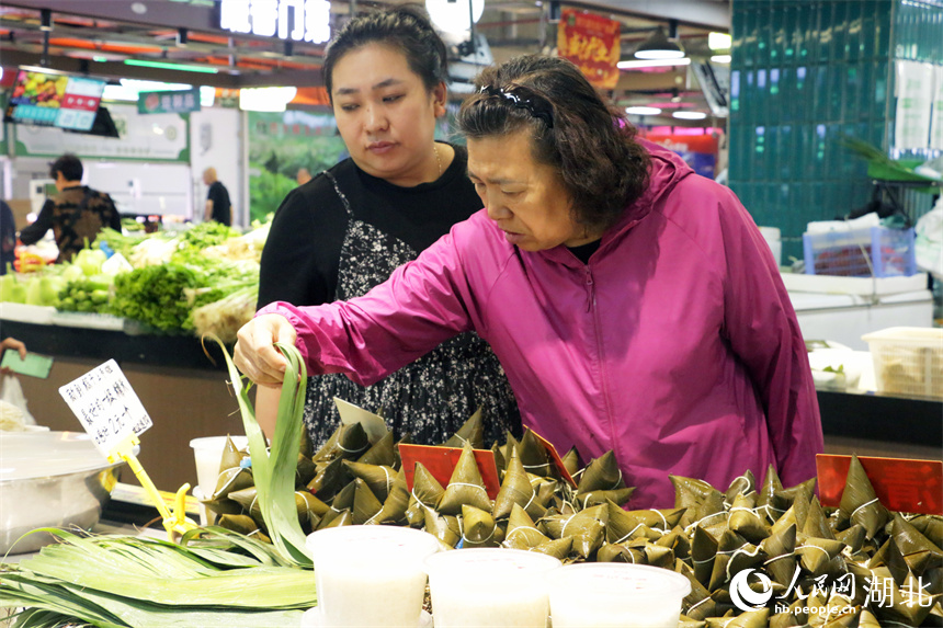 端午將至，洪山廣場地鐵站菜市場擺出了粽葉、手工粽子等節(jié)日美食，供市民挑選。人民網(wǎng)記者 周恬攝